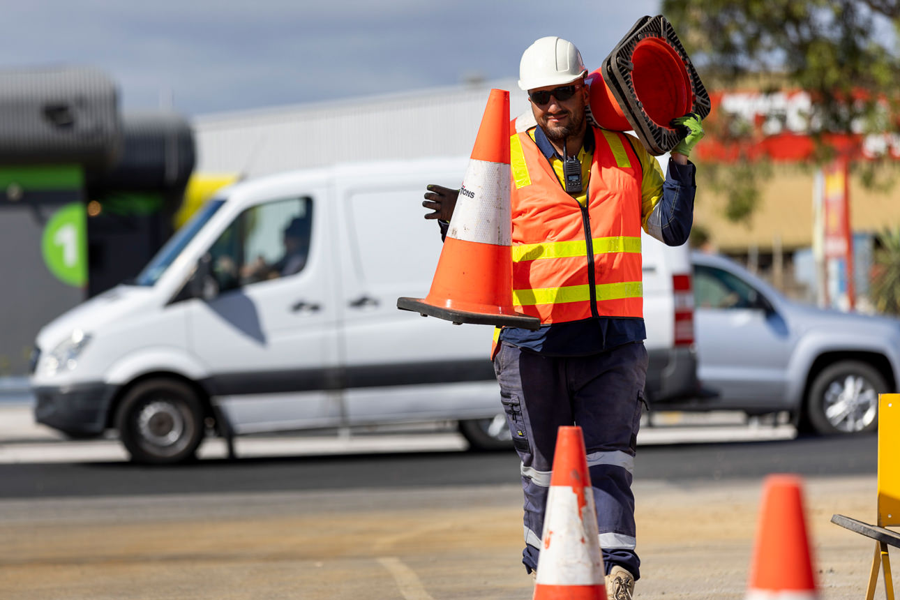 Traffic management male employee laying out witches hats